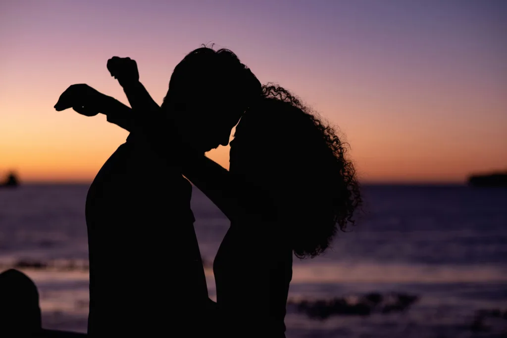 10 أشياء يحبها الرجل في المرأة ولا يبوح بها (لن تتوقعي بعضها!) a silhouette of a man and woman dancing at sunset